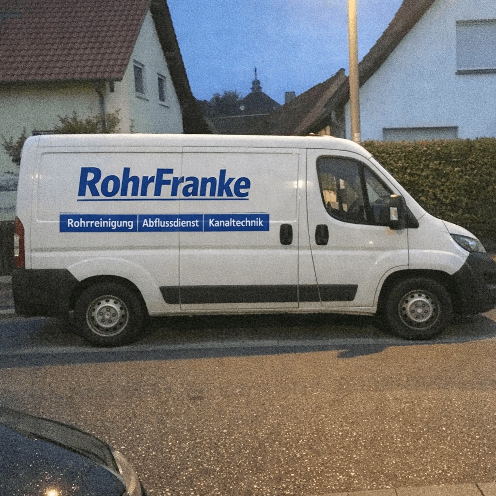 Monteur in Arbeitskleidung prüft ein verstopftes WC in einem hellen Badezimmer